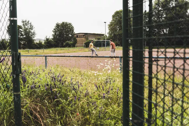 focused_176841982-stock-photo-two-men-playing-football-cinder
