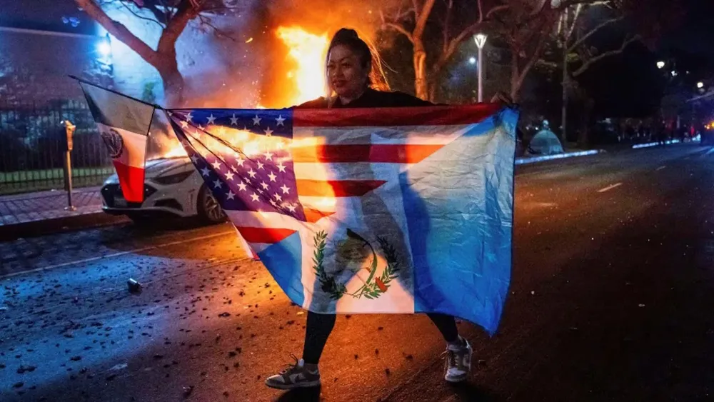 una-mujer-latina-despliega-multiples-banderas-en-una-sola-como-simbolo-de-la-lucha-de-la-comunidad-latina-foto-ap-H6IFBQJBFBETLE3XX2ROZET5R4