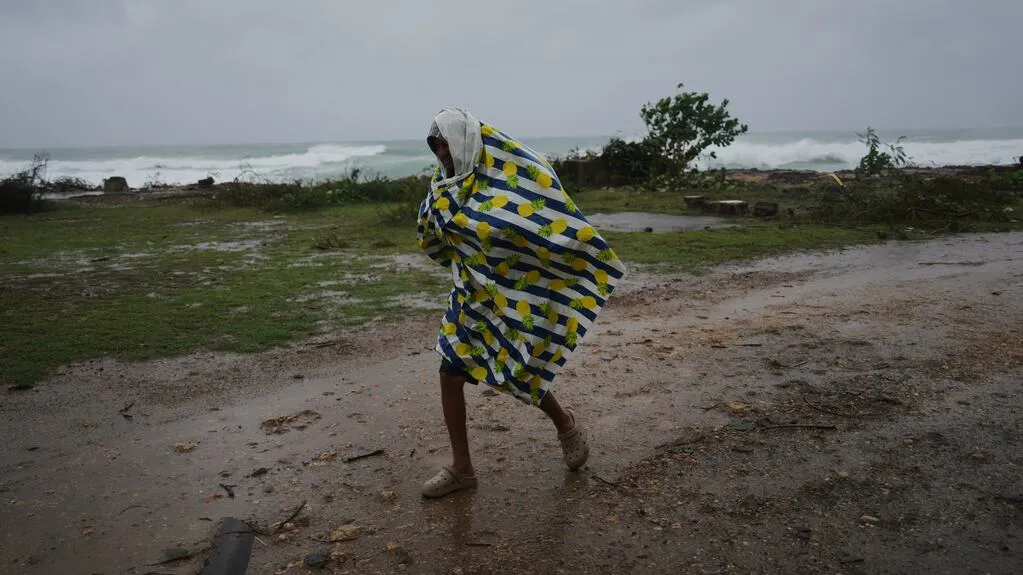 un-hombre-camina-bajo-la-lluvia-antes-de-la-llegada-del-huracan-melissa-en-canizo-una-localidad-en-santiago-de-cuba-el-28-de-octubre-de-2025-ap-fotoramon-espinosa-YZG2PE4FWBH6TOAEIGDVHVP5KE
